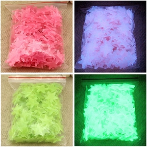 Detailed comparison of pink and green glowing star wall stickers in light and dark settings