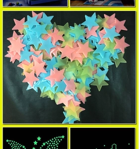 Macro shot of colorful glow in the dark plastic star stickers arranged in a heart shape