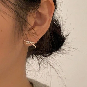 Minimalist 925 sterling silver bow knot stud earrings worn on female ear for daily style