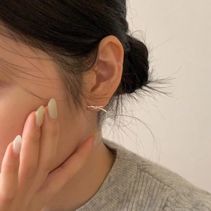 Close-up of a 925 silver bow stud earring worn on the ear showing delicate knot details
