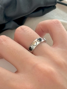 Detail of 925 sterling silver wide ring featuring hollow hearts and black zircon stone