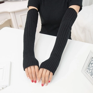Close-up of black 50cm knitted arm sleeves worn by a model on a white surface