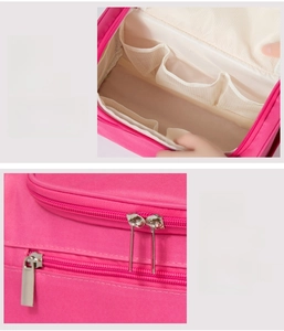 Detail of rose pink travel bag featuring mesh compartments and smooth metal zipper closure