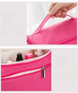 Detail of rose red travel toiletry bag showing reinforced handle and rear zipper pocket