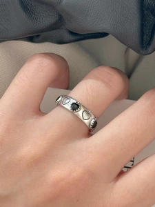 Close-up of a 925 sterling silver ring with alternating black hearts and silver outlines