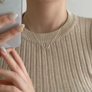 Minimalist silver infinity necklace on model with an elegant simple link chain