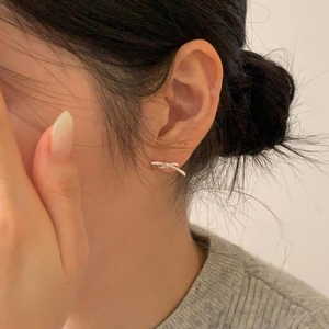 Close-up of minimalist 925 sterling silver bow knot stud earring on female ear