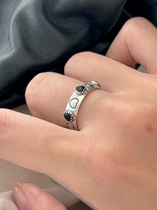 Macro detail of S925 silver ring featuring black heart stones and punk heart engravings