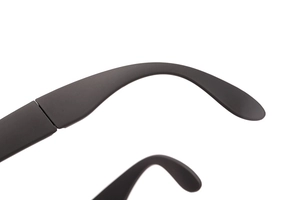 Close-up of matte black folding sunglasses arm with detailed temple curve on white background