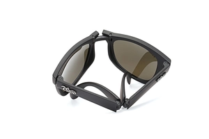 Detailed top view of matte black folding sunglasses showing hinge structure and silver logo