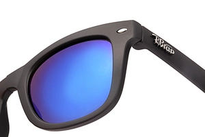 Detail view of foldable sunglasses hinge with metallic logo and blue mirrored lens