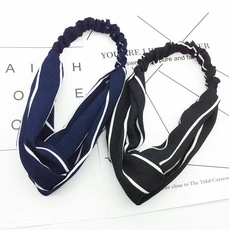 Detail of black and navy blue elastic striped headbands on minimalist display cards