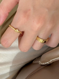 Detail of gold star and dot embossed stackable sterling silver rings with pearl texture