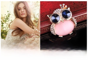Macro view of owl brooch featuring pink opal body and sparkling blue crystal eyes