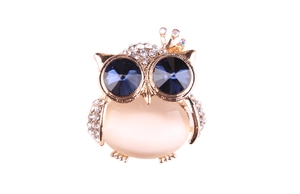 Close-up of owl brooch featuring blue crystal eyes and opal gemstone inlay detail