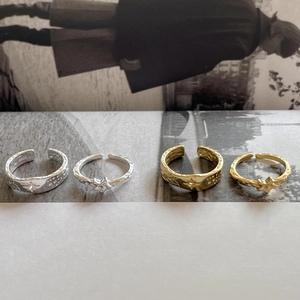 Detail of S925 sterling silver rings with embossed star patterns in gold and silver tones