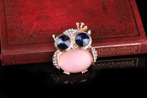 Detail of owl brooch with pink opal body, blue crystal eyes and gold-tone finish
