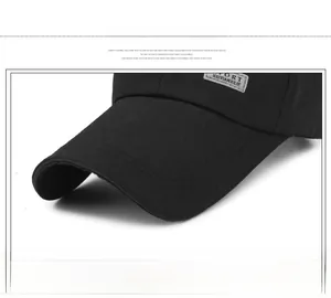 Detail of the curved brim and sport label on a black canvas baseball cap for men