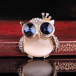 Exquisite gold-plated owl brooch with blue crystal eyes and opal body on a vintage box