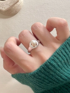 Close-up of elegant S925 silver pearl ring worn against a cozy green knit sweater