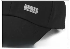 Detail of black sports cap showing breathable fabric texture and sport label stitching