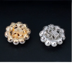 Detailed back view of flower brooch with pearl trim and dual safety clip fasteners