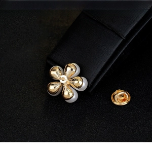 Detail of five-petal gold flower brooch with white pearls and butterfly clutch back