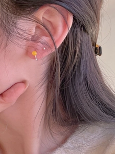 Detailed view of a minimalist 925 sterling silver stud earring with yellow amber bead