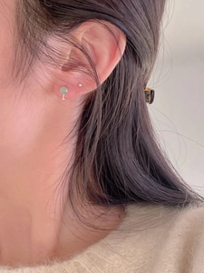 Close-up of minimalist 925 silver stud earrings with light green round gemstone bead