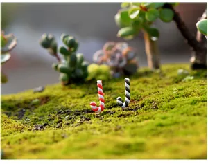 Photo macro de figurines de cannes en sucre rouges et noires sur mousse pour micro paysage