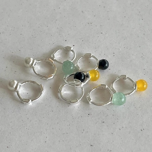 Detailed close-up of S925 sterling silver hoop earrings with colorful pearl beads on stone