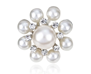 Macro detail of silver floral brooch featuring central pearl and sparkling crystal pavé
