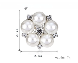 Detailed view of silver flower brooch with white faux pearls and sparkling rhinestones