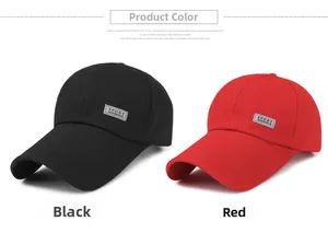 Detail view of black and red canvas baseball caps with sport patch on white background