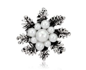 Macro detail of retro pearl flower brooch with silver antique metal leaf texture