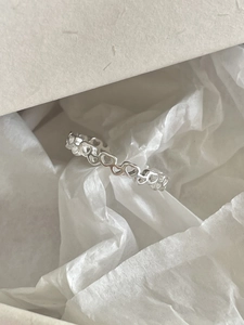 Detailed view of 925 sterling silver ring with hollow heart link design on white paper