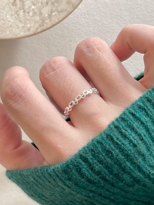 Detailed close-up of 925 sterling silver ring with hollow heart pattern on hand