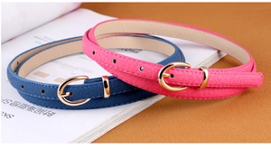 Detail of slim PU leather belts in navy blue and rose red with gold metal buckles