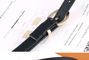 Detail of black lychee texture leather belt with golden oval metal pin buckle closure