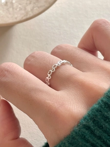 Close-up of 925 sterling silver hollow heart band ring worn on a finger