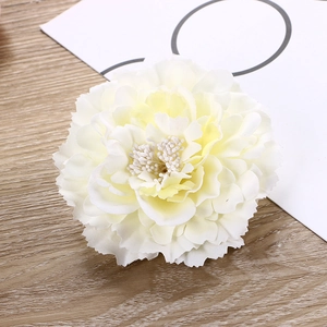 Detailed close-up of a cream-colored silk peony flower clip on a wooden background