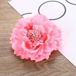 Close-up of pink fabric peony hair clip showing layered petals and detailed texture