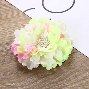 Close-up of artificial peony flower head with pink and yellow gradient silk petals