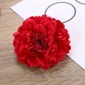 Detail of a red artificial peony head in silk fabric with multi-layered petals