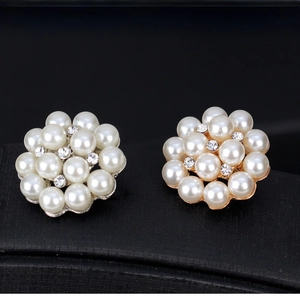 Detail of cluster pearl flower pins with sparkling rhinestones in gold and silver finish