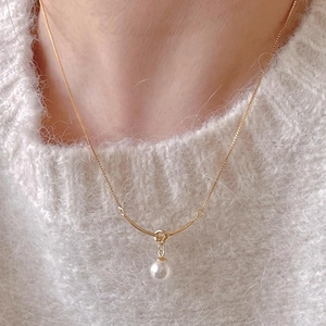Elegant 925 sterling silver gold necklace with round pearl pendant on white sweater