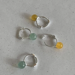 Detail of 925 sterling silver hoop earrings with yellow and green crystal bead charms