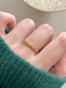 Close-up of golden hollow heart ring on a finger showing elegant jewelry details