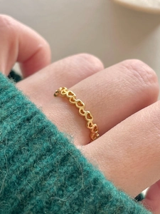 Detail of a gold heart chain ring made of 925 sterling silver with a vintage hollow design