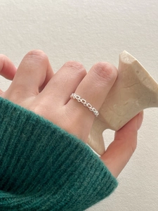 Close-up of 925 sterling silver ring with continuous heart cut-outs on a finger